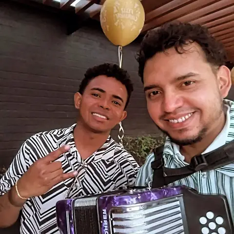 Dos integrantes de Vallenato Bogotá Live con acordeón y un globo de feliz cumpleaños